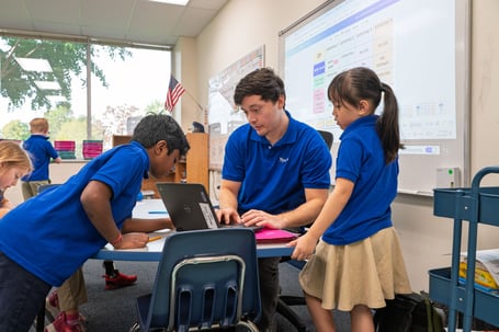 Teacher guiding two students through a math activity during small-group instruction