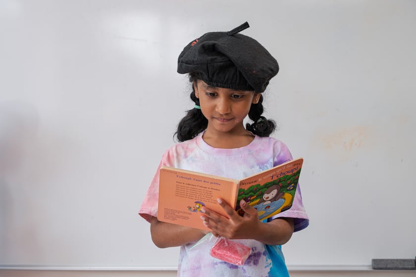 Kindergarten French Student Reading A French Children's Book