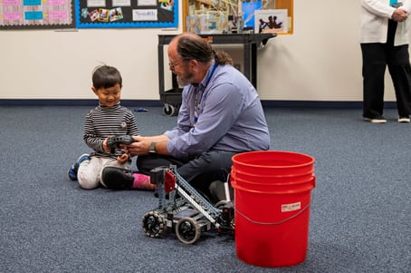 Mr. Fremlin working with preschool students on robots