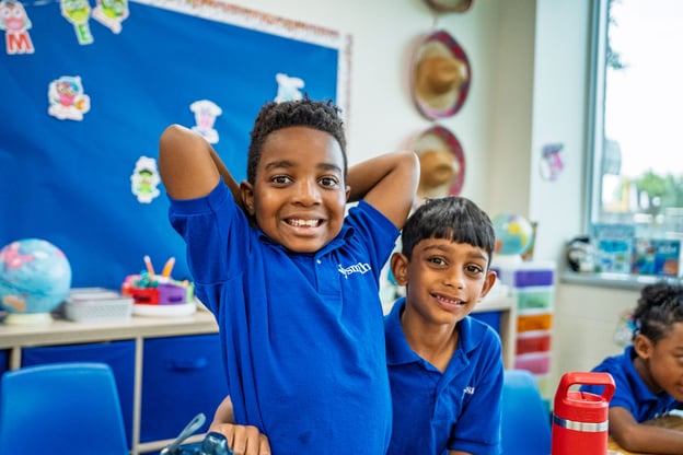Smiling kindergarten classmates posing together in a joyful, welcoming school community
